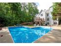 Relaxing backyard oasis featuring a large in-ground pool, deck, and surrounded by mature trees at 206 Kingsley Way, Woodstock, GA 30188