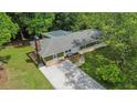 Aerial view of the home with a long driveway, a backyard fire pit, and a carport at 3852 Drew Campground Rd, Cumming, GA 30040