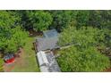 An aerial view shows the home, driveway, canopy, wooded backyard, and storage shed at 3852 Drew Campground Rd, Cumming, GA 30040