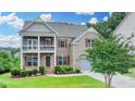Charming two-story home with brick facade, covered porch, dormers, and landscaped yard at 5770 Bridleton Xing, Suwanee, GA 30024