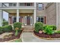 Charming brick home with a covered front porch, mature landscaping, and a welcoming entrance at 5770 Bridleton Xing, Suwanee, GA 30024