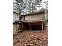 An exterior shot of the back of a house with rotting eaves and a yard full of leaves at 711 Alfred Nw Rd, Atlanta, GA 30331