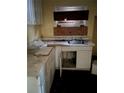 A dirty kitchen with a stainless steel sink, dingy cabinets, and a boarded up window at 711 Alfred Nw Rd, Atlanta, GA 30331