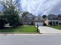 Attractive brick home boasts a well-kept lawn and a driveway leading to a two-car garage at 458 Vinings Vintage Cir, Mableton, GA 30126