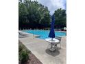 Community pool with lounge chairs and a table with umbrella for residents at 458 Vinings Vintage Cir, Mableton, GA 30126