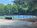 Outdoor community tennis court with blue and green surface surrounded by a fence at 458 Vinings Vintage Cir, Mableton, GA 30126