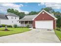 Well-maintained brick house with a front porch, attached garage, and green lawn at 528 Savannah Rose Way, Lawrenceville, GA 30045