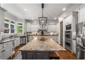 Gourmet kitchen with a large center island, stainless steel appliances, and custom white cabinetry at 5605 Copper Creek Pass, Cumming, GA 30040