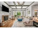 Inviting living room with coffered ceiling, a stone fireplace, and abundant natural light at 5605 Copper Creek Pass, Cumming, GA 30040