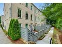 Charming brick townhome showcasing private fenced-in patio with cozy seating and lush landscaping at 302 Boxwood Ln, Roswell, GA 30075