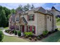 A beautiful two-story home featuring brick and stone exterior, with manicured lawn and lush landscaping at 332 Warwick Pl, Mcdonough, GA 30253