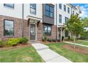 Beautiful brick townhome with manicured lawn, featuring modern architectural details and a welcoming entrance at 5448 Howington E Ct # 194, Buford, GA 30518