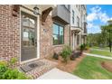 Charming brick townhome featuring a covered entrance and professionally landscaped front yard at 5448 Howington E Ct # 194, Buford, GA 30518
