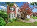 Charming two-story home featuring bay windows, brick accents, manicured lawn, and mature landscaping at 1100 Carrington Pkwy, Villa Rica, GA 30180