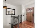 Upstairs hallway featuring hardwood floors, black railing, modern lighting fixture, and a door with glass pane windows at 2148 Allgood Rd, Marietta, GA 30062