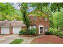 Charming two-story brick home with attached garage and lush green surroundings at 101 Swanton Hill Ct, Decatur, GA 30030