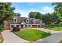 Attractive home with a spacious lawn, 3-car garage, and dormer windows under a bright sky at 150 South St, Buford, GA 30518