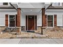Inviting front porch with decorative stone accents, wood columns, and attractive wood door at 150 South St, Buford, GA 30518