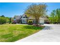 A beautiful home featuring a well-manicured lawn and driveway, with mature trees and landscaping at 815 Spring View Ct, Covington, GA 30014