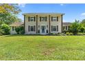 Charming two-story home with a manicured front lawn and a welcoming entrance with a blue door at 75 Auburn Rd, Auburn, GA 30011