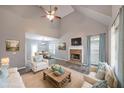 Bright living room features a stone fireplace, vaulted ceilings, and ample seating, enhanced by natural light from large windows at 36 Laurel Ne Way, White, GA 30184