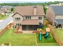 Aerial view of backyard features including screened patio, playground, and fenced yard at 4015 Roberts Crest Ln, Suwanee, GA 30024