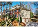 Brick home with an attached three-car garage, blue shutters, and manicured lawn at 4506 Westcliff Ne Trce, Roswell, GA 30075