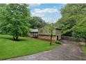 Landscaped home with stone accents and long driveway surrounded by mature trees at 251 Sabrina Ct, Woodstock, GA 30188