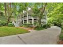 Elegant home featuring a long driveway, manicured lawn, and a charming two-story design at 400 Old Ivy Ne Rd, Atlanta, GA 30342