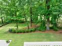 Well-maintained backyard with lush green grass and mature trees, offering a private outdoor space at 5844 Brookstone Nw Walk, Acworth, GA 30101