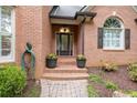 Elegant entryway with brick steps, potted flowers, and a stylish glass-paneled front door at 5844 Brookstone Nw Walk, Acworth, GA 30101