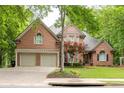 Charming two-story brick home featuring a three-car garage and a beautifully landscaped front yard at 5844 Brookstone Nw Walk, Acworth, GA 30101