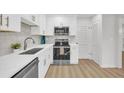 Modern white kitchen with stainless steel appliances and quartz countertops at 1 N Boundary Nw Pl, Atlanta, GA 30318