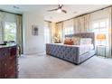 Spacious main bedroom featuring a tufted bed, plush carpeting, and large windows with stylish curtains at 2067 Telfair Circle # A&B, Atlanta, GA 30324
