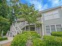 Two-story condo with light gray siding, complemented by white trim and vibrant landscaping, creates a welcoming facade at 212 Abingdon Way, Atlanta, GA 30328