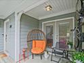 Cozy covered porch furnished with a unique egg chair and bistro set, perfect for relaxing outdoors at 212 Abingdon Way, Atlanta, GA 30328