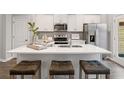 Modern kitchen with a large center island, stainless steel appliances, white cabinets and stylish pendant lighting at 5649 Hislop Ln # 90, Mableton, GA 30126