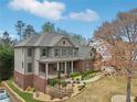 Charming two-story home features a brick-and-siding exterior, a landscaped yard and a welcoming front porch at 1870 Marcia Overlook Dr, Cumming, GA 30041
