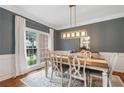 Bright dining room with a large window, stylish lighting, and a classic dining set at 2772 Hillgrove Dr, Dacula, GA 30019