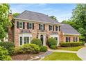 Stately two-story brick home with manicured landscaping, black shutters, and a well-maintained lawn at 360 Spindle Ct, Sandy Springs, GA 30350