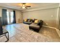 Comfortable living room with couch, tile floors, and light-filled patio door at 125 Rue Fontaine, Lithonia, GA 30038