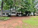 Traditional ranch home with a covered porch surrounded by mature trees at 1905 Sidneys Cv, Lawrenceville, GA 30043