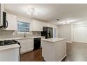 Bright kitchen features sleek, white cabinets, stainless steel appliances, and a center island at 5352 Windfern Ct, Stone Mountain, GA 30088
