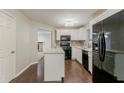 Modern kitchen boasts white cabinets, black appliances, and a functional center island at 5352 Windfern Ct, Stone Mountain, GA 30088