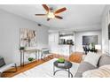 Cozy living room with modern decor open to the kitchen, featuring a ceiling fan and hardwood floors at 1075 Peachtree Walk # A-307, Atlanta, GA 30309