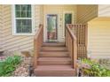 Inviting front porch with wooden stairs, decorative rock landscaping, and glass front door at 1137 Poplar Log Pl, Austell, GA 30168