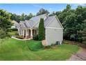 Lovely side view of a home with mature trees, stone accents, and well-manicured lawn at 12 Isabella Ne Ct, Cartersville, GA 30121