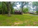 A log cabin with a porch sits on a spacious lot with mature trees, offering a peaceful retreat at 218 Green Acre Ln, Cartersville, GA 30121