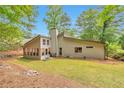 A private backyard has a sunroom, lots of grass, and is surrounded by mature trees offering shade and beauty at 2000 Kristian Way, Roswell, GA 30076