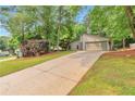 Suburban home with an extra long driveway, a two-car garage and lots of beautiful trees in the front yard at 2000 Kristian Way, Roswell, GA 30076